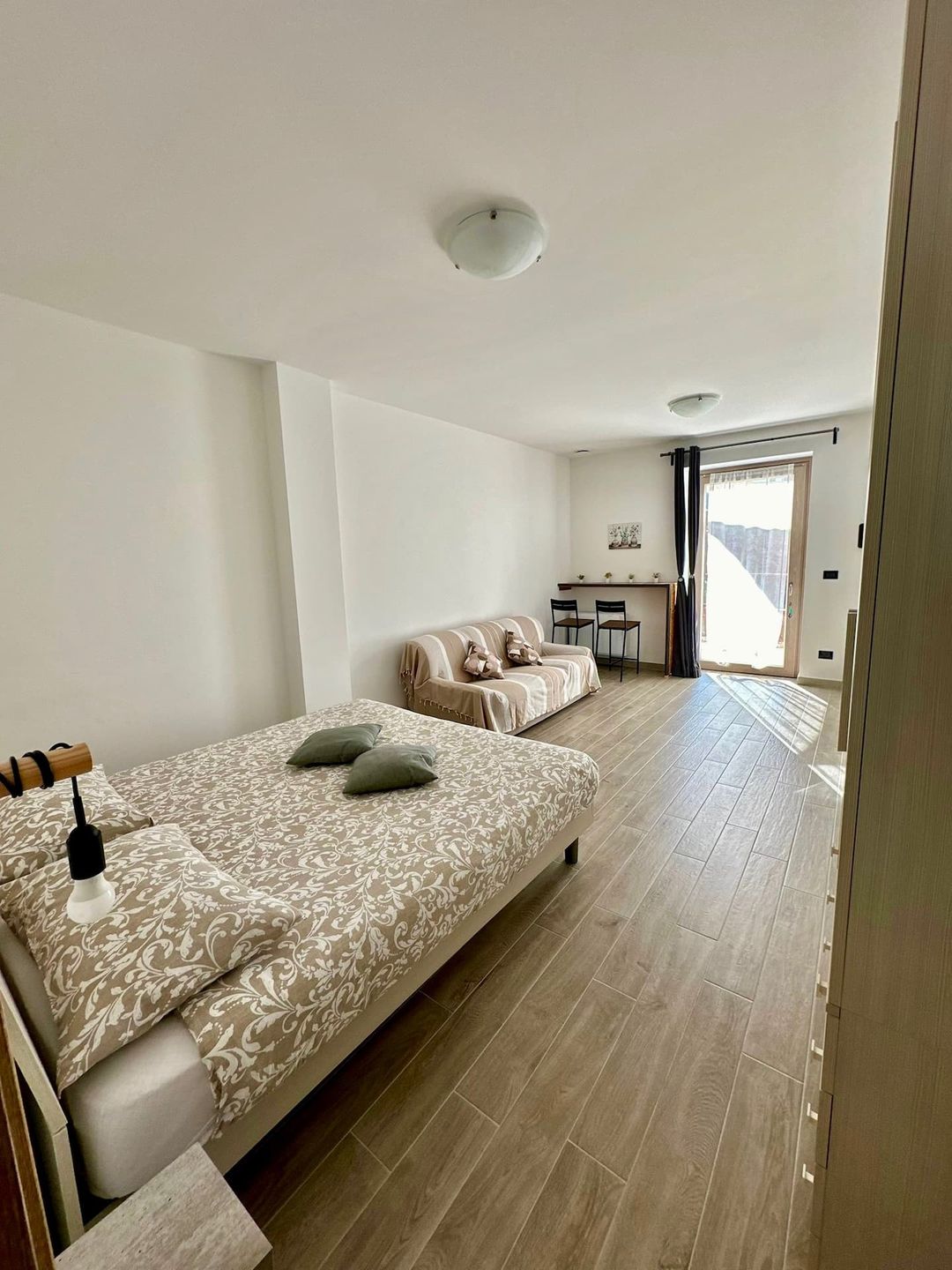 Camera Buddy: letto matrimoniale e divano letto verso la porta a vetri