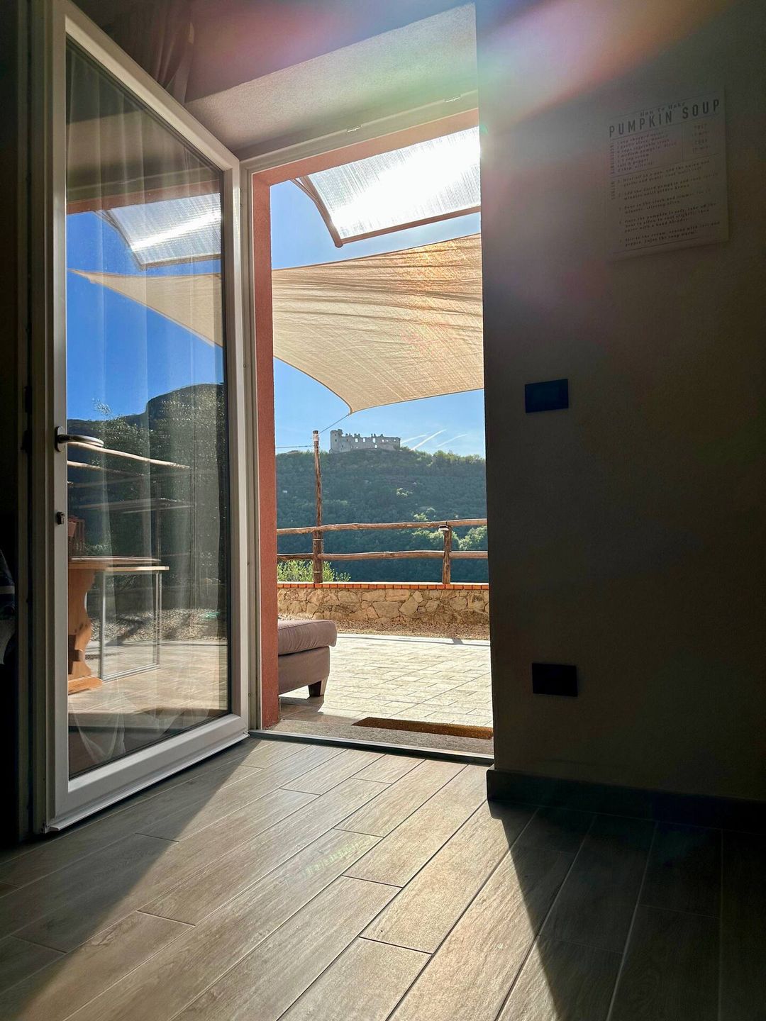 La porta a vetri della camera Buddy aperta sulla valle e su Castel Gavone