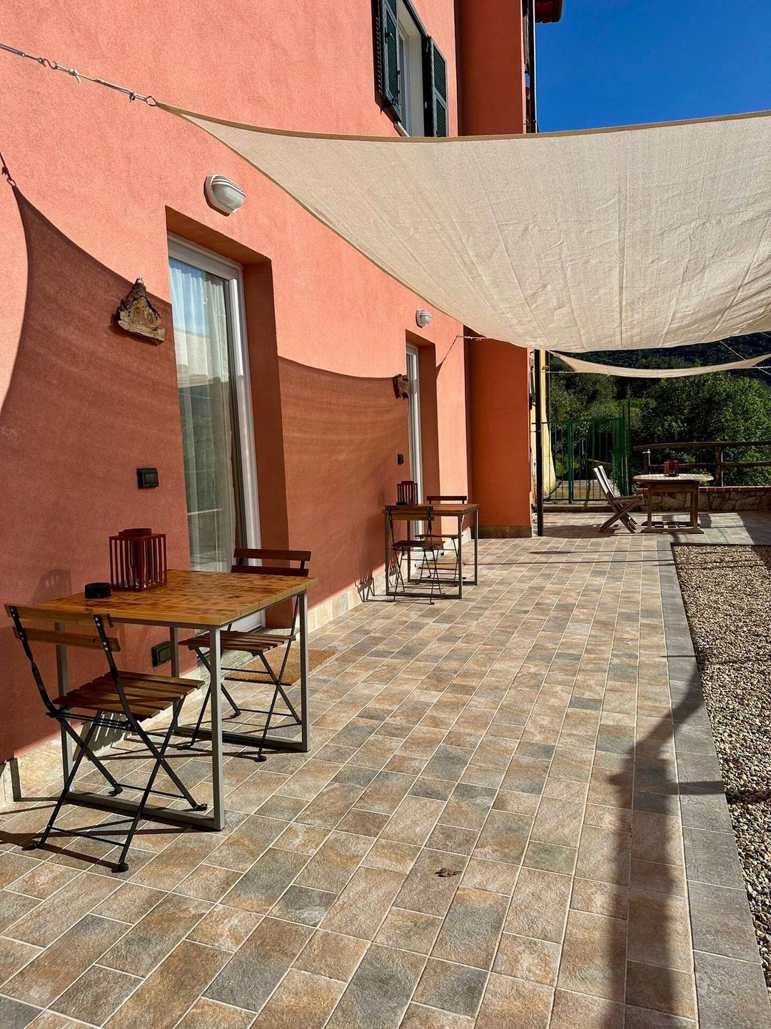 Il patio esterno con i tavoli e le vele ombreggianti